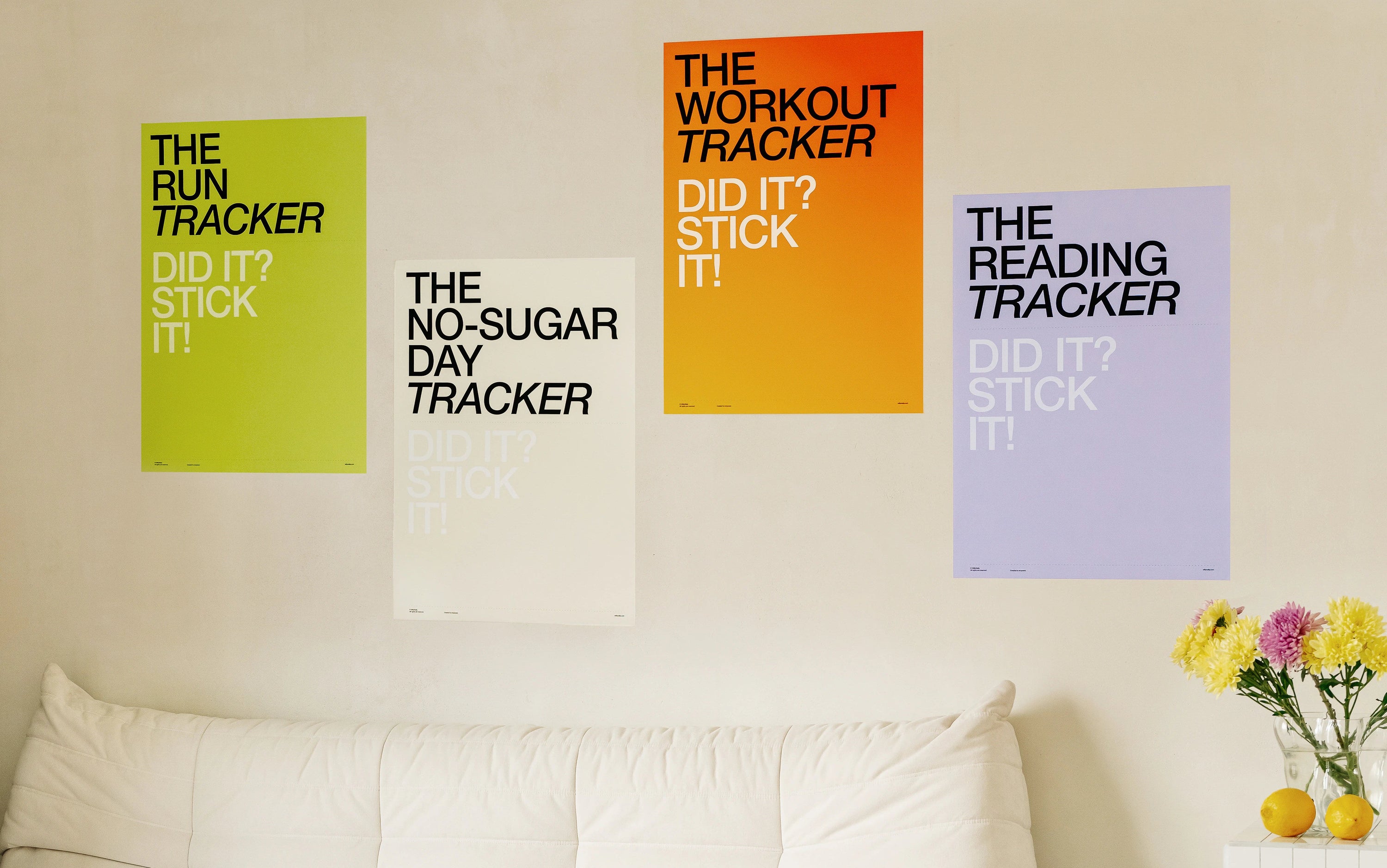 Colorful motivational posters on a wall above a white sofa in a living room.