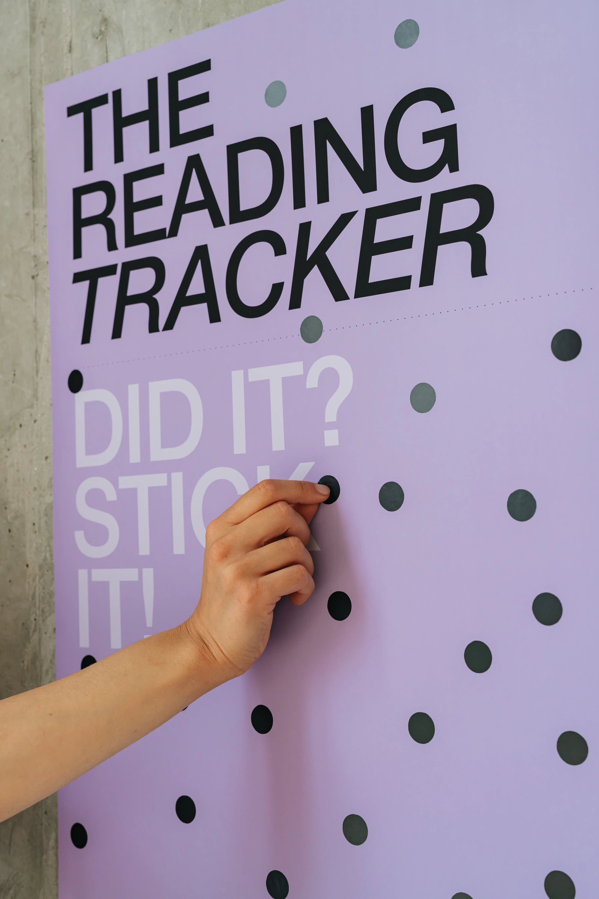 Purple poster with 'The Reading Tracker' and a hand interacting with it.