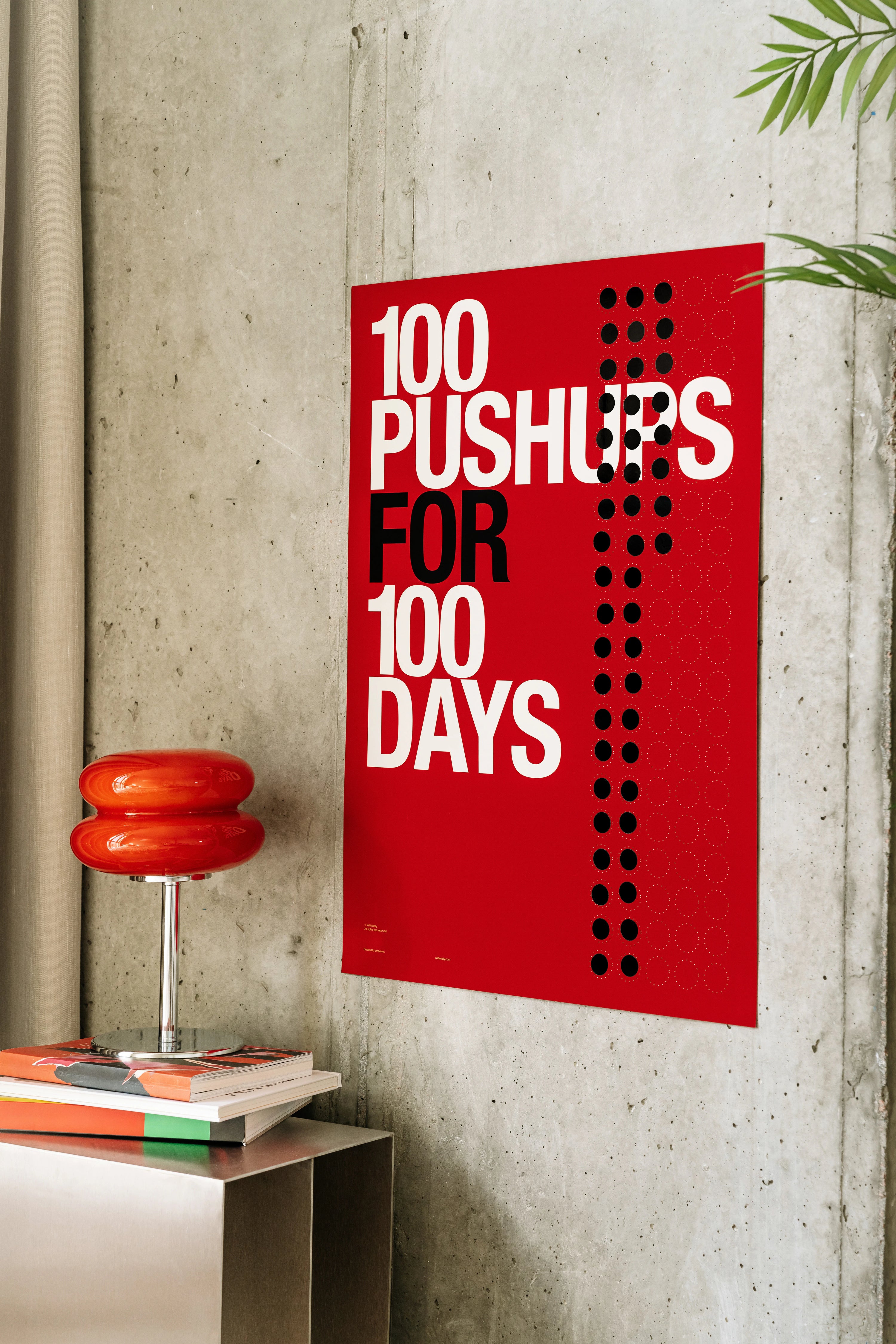 Red poster with '100 Pushups for 100 Days' text on a concrete wall.