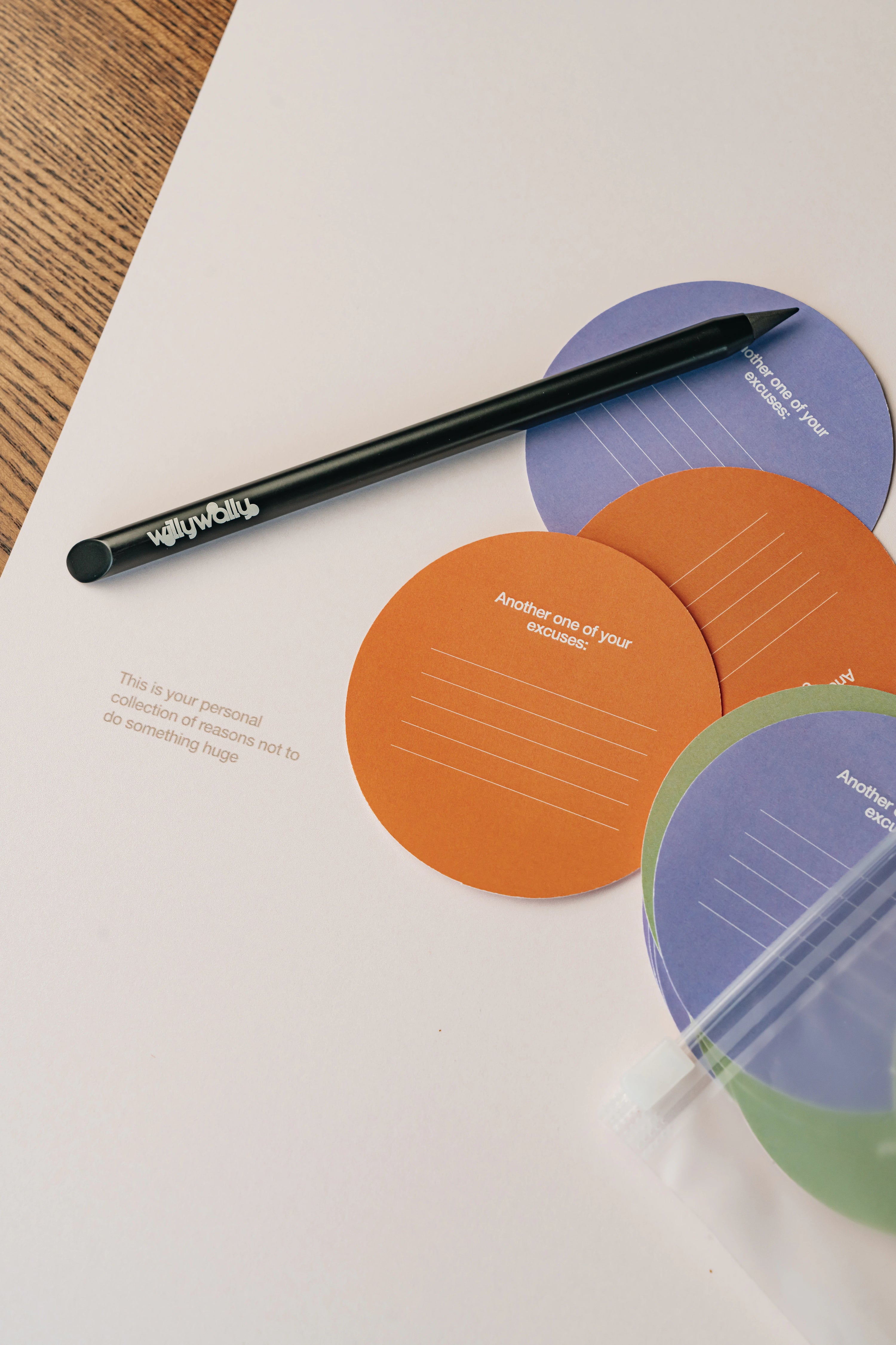 Colorful circular notepads with a pen on a white surface